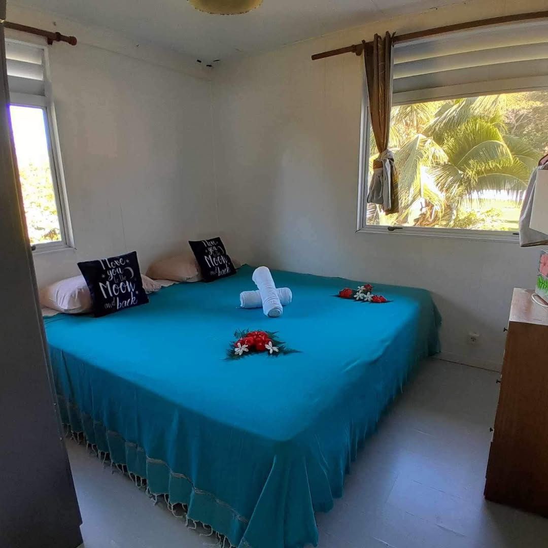 Chambre avec grand lit et dessus de lit turquoise